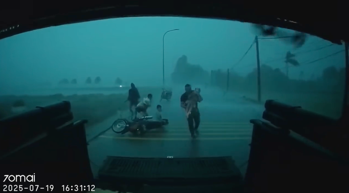 Hình ảnh anh Lều Đức Việt giải cứu người phụ nữ cùng 5 bé nhỏ giữa đường gây xúc động mạnh. (Ảnh cắt từ clip)