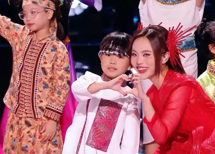 Phương Mỹ Chi xúc động tạo hình trái tim với một trong 30 em nhỏ xuất hiện tại tiết mục Một bó đũa. Ảnh chụp màn hình