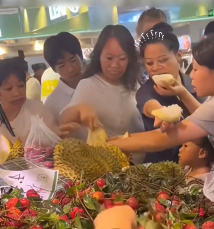 Nhiều khách hàng thản nhiên bóc ăn sầu riêng tại quầy dùng thử. (Ảnh: Douyin)