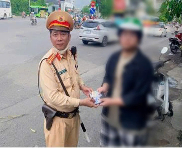 Nam sinh P nhận lại tài sản thất lạc từ các chiến sĩ CSGT. Ảnh: Công an TP Hà Nội