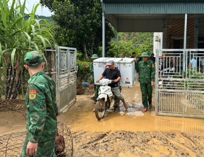 Lực lượng chức năng giúp bà con vùng lũ di chuyển đến nơi an toàn. Ảnh: Báo Người Lao Động