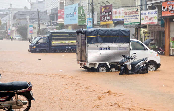 Nhiều xe tải lớn dừng chặn giữa đường để cảnh báo khu vực ngập lụt. Ảnh: N.X