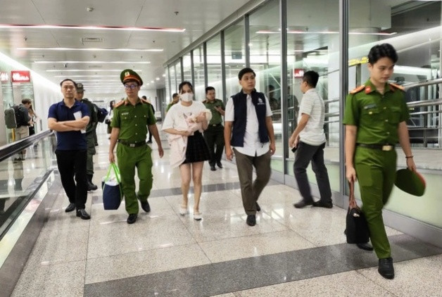 Ngô Thị Thêu bế con nhỏ bị dẫn giải về nước.