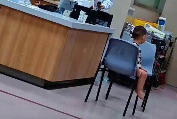 Bé trai ngồi lặng lẽ ở sở cảnh sát. Ảnh: China Press