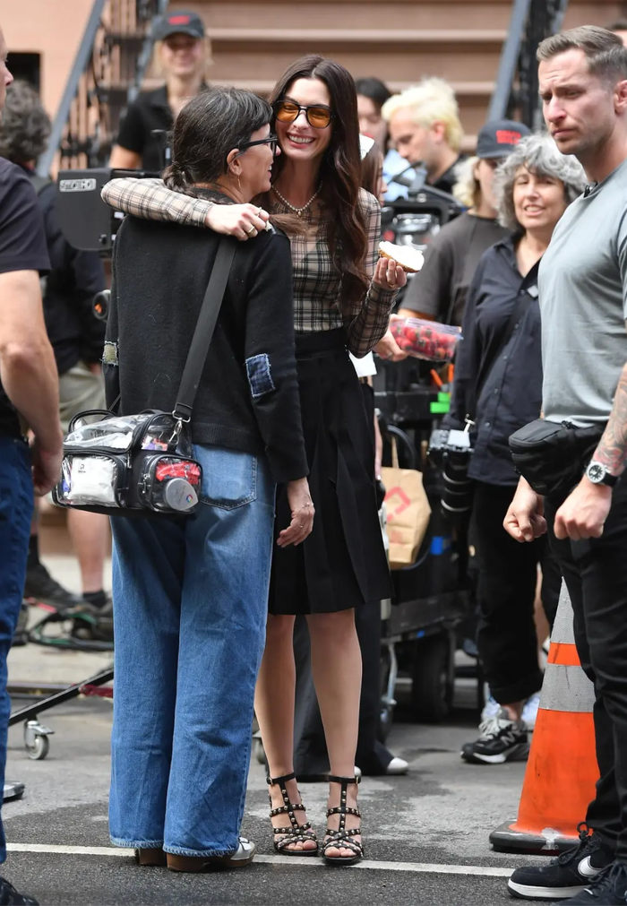 Anne Hathaway bám vào một thành viên trong đoàn sau khi bị ngã sõng soài trên bậc thang. Ảnh: BACKGRID