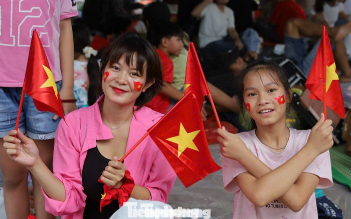 Rợp bóng cờ đỏ từ đường phố đến các hàng người ngồi đón đợi buổi tổng duyệt. (Ảnh Tiền phong)