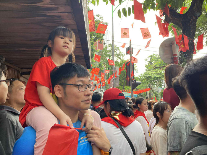 Một em nhỏ cùng người thân háo hức đón đợi các đoàn diễu binh, diễu hành đi qua các tuyến phố trung tâm Hà Nội. (Ảnh Phương Thảo)