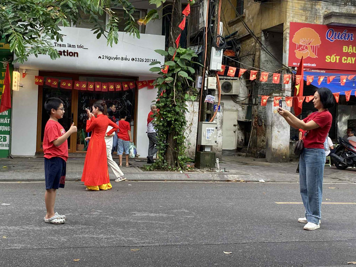 Một em nhỏ được người thân chụp ảnh để lưu giữ kỷ niệm trong ngày diễn ra buổi tổng duyệt. (Ảnh Phương Thảo)