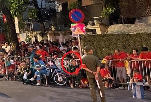 Bác N.V.L cầm cờ ngồi chính giữa và gia đình được bố trí ghế ngồi trước hàng rào bảo vệ trên đường Nguyễn Thái Học. Ảnh: Công an TP Hà Nội