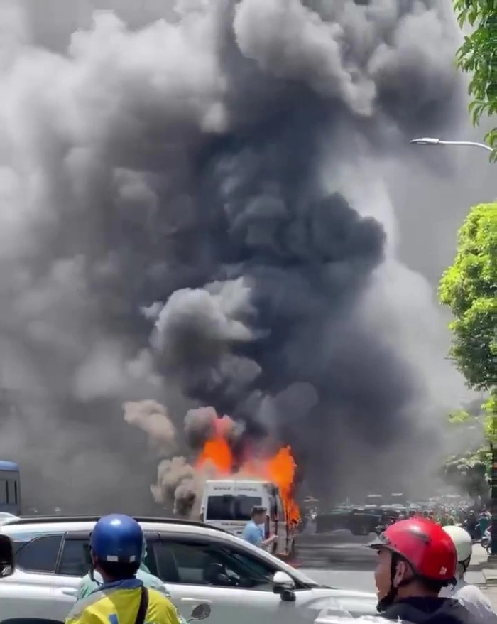 Xe ô tô bốc cháy dữ dội, cột khói đen bốc lên cao nghi ngút. Ảnh: Tuổi Trẻ Online