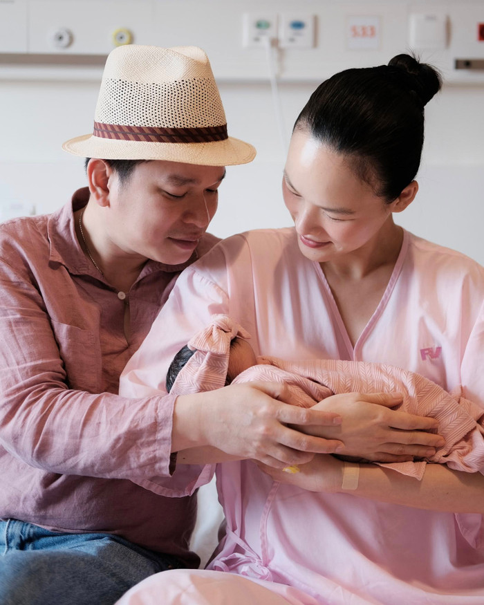 Vợ chồng nữ người mẫu thể hiện sự nâng niu, trân trọng khi bế con gái đầu lòng. Ảnh: FBNV