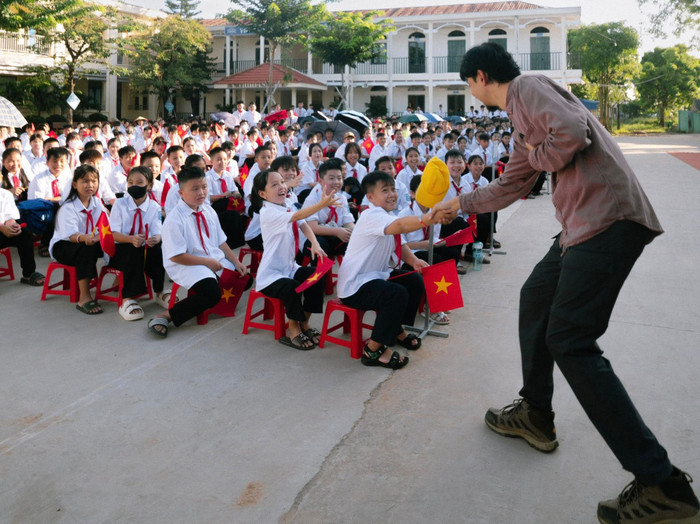 Đen Vâu bắt tay một em bé tại điểm trường. (Ảnh: FBNV)