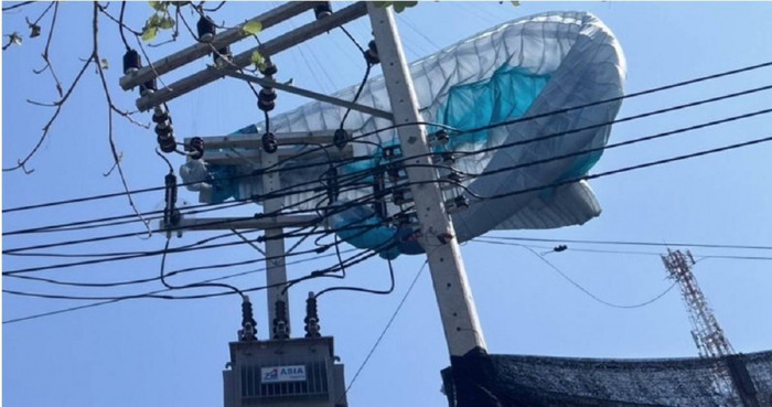 Du khách nước ngoài mắc kẹt trên cột điện cao thế khi chơi dù lượn, cảnh tượng khiến người dân xôn xao Ảnh 1