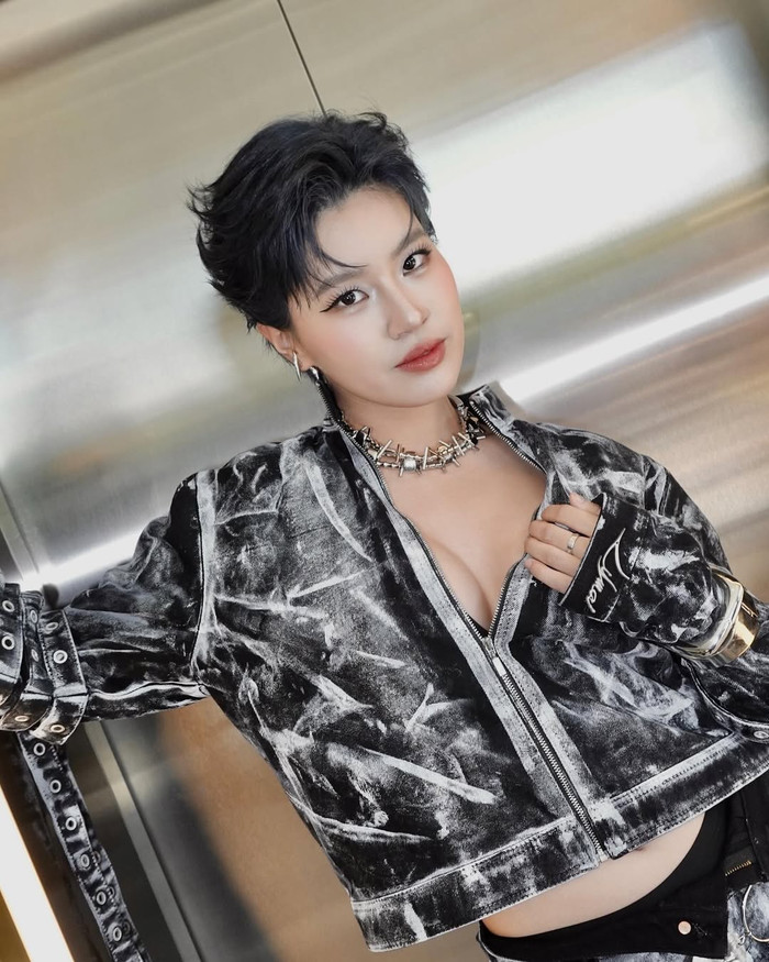 ...đến outfit bomber jacket velvet xám bạc metallic với vòng cổ choker gai góc, crop top khoét sâu khoe vòng một đầy đặn - tất cả đều toát lên tinh thần phá cách đặc trưng của nữ rapper sinh năm 2003. Ảnh: IGNV