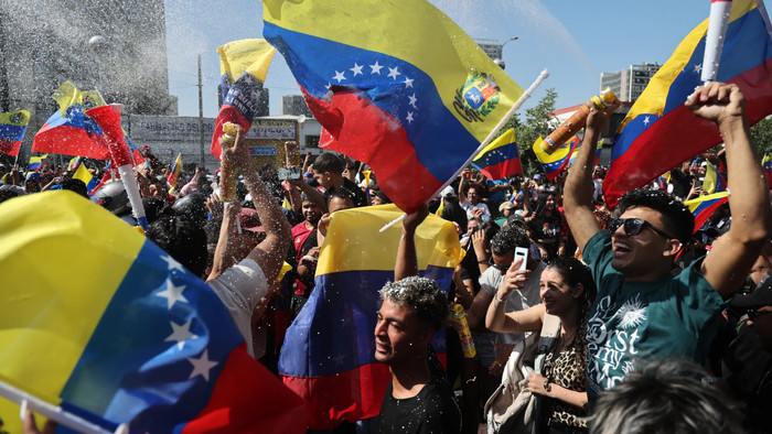 Người Venezuela sống tại Chile ăn mừng ở Santiago vào ngày 3 tháng 1 năm 2026, sau khi lực lượng Mỹ bắt giữ nhà lãnh đạo Venezuela Nicolas Maduro sau cuộc tấn công quy mô lớn vào Venezuela. (Ảnh của Javier TORRES / AFP qua Getty Images).