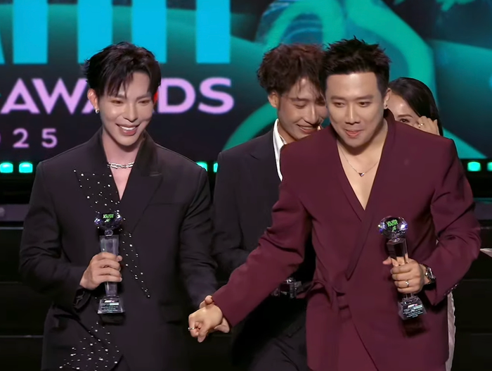 Trấn Thành nắm tay Erik cùng xuống sân khấu sau khi nhận giải. Ảnh chụp màn hình