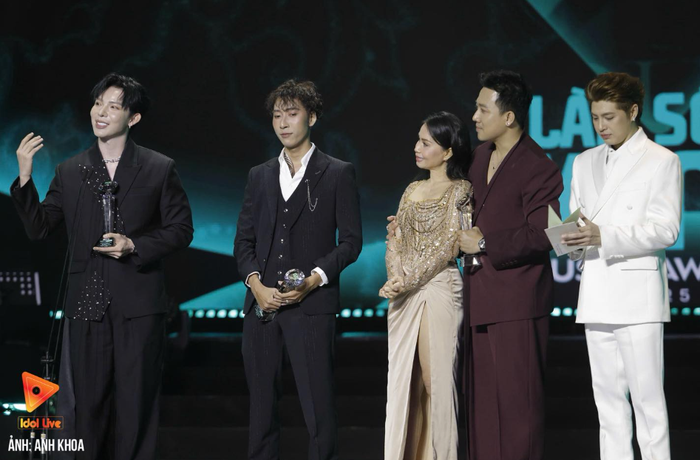 Khoảnh khắc Trấn Thành chủ động nhường cúp cho Erik và nhạc sĩ Nguyễn Phúc Thiện và lùi về phía sau để Erik phát biểu được khán giả đánh giá cao về sự tinh tế (Ảnh: Anh Khoa)