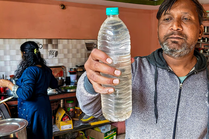 Một người dân đang cho xem mẫu nước uống được thu thập sau vụ dịch tiêu chảy do nước bị ô nhiễm gây ra, tại khu vực Bhagirathpura, Indore, Madhya Pradesh. | Ảnh: PTI