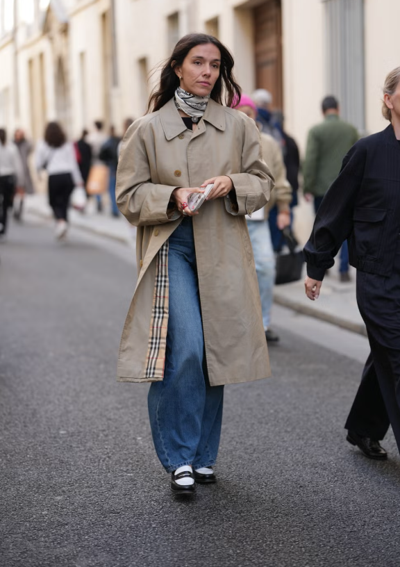 Áo khoác dáng dài cổ điển có thể phối với mọi thứ, kể cả quần jeans ống rộng yêu thích của bạn. Hoàn thiện vẻ ngoài với giày lười hai màu và khăn lụa để có phong cách Hollywood cổ điển hoàn hảo. Ảnh: Cosmopolitan