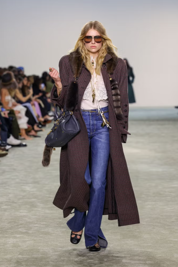 Quần cạp cao được phối cùng áo sơ mi ren, áo khoác dài kẻ caro và giày búp bê quai chữ T. Ảnh: Cosmopolitan