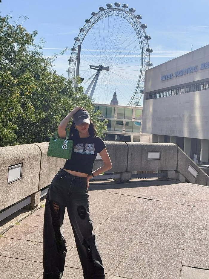 Jisoo của BLACKPINK thu hút mọi ánh nhìn bằng cách chọn áo thun crop top in họa tiết và quần jeans ống rộng. Kiểu dáng này làm nổi bật vòng eo thon gọn của cô và giúp bộ trang phục không bị nhàm chán. Một chiếc túi màu xanh lá cây cá tính cũng là một lựa chọn hoàn hảo để hoàn thiện bộ trang phục. Ảnh: IGNV