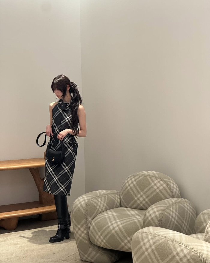 Mẫu Moka của ILLIT xuất hiện với họa tiết kẻ caro xanh trắng, kết hợp cùng quần tất, bốt và túi xách màu đen. Trông tổng thể khá đơn giản, chính họa tiết là điểm nhấn tạo sự khác biệt và mang đến sự nổi bật cho bộ trang phục. Ảnh: IGNV