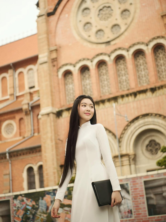 Thiết kế cổ cao truyền thống kết hợp chất liệu voan hoặc lụa mỏng tạo cảm giác nhẹ nhàng, bay bổng. Lọ Lem khi diện áo dài giống như một nàng thơ đang dạo bước giữa phố phường. Màu trắng thuần khiết không chỉ làm nổi bật làn da trắng hồng mà còn gợi lên vẻ đẹp thuần khiết, e ấp - đặc trưng khiến nhiều người liên tưởng đến hình ảnh thiếu nữ Việt Nam trong tranh Đông Hồ. Ảnh: IGNV