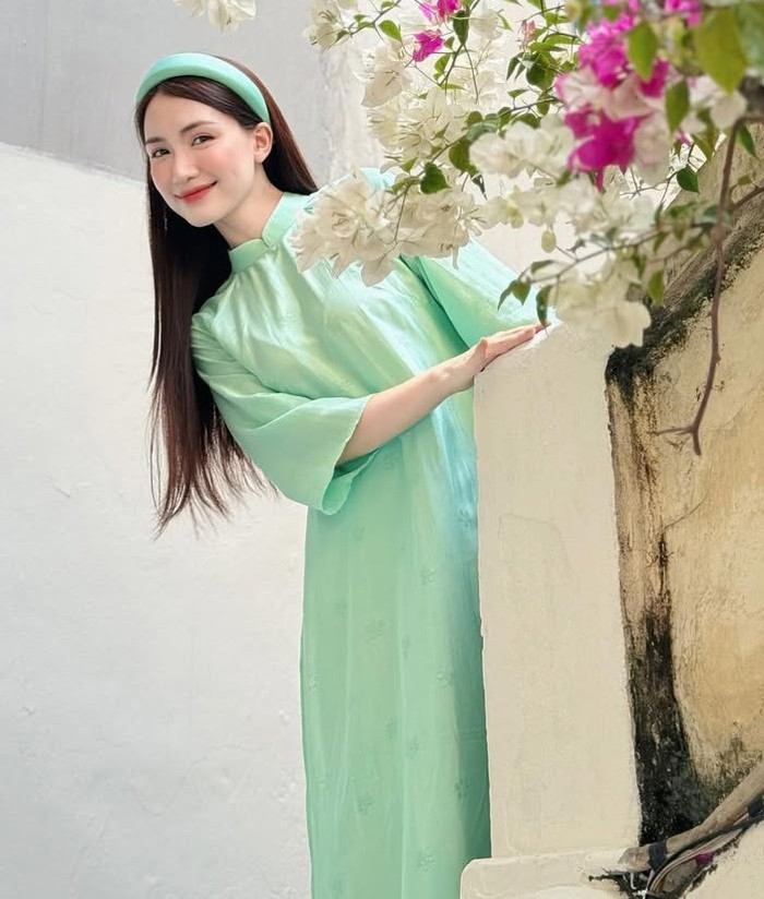 Cuối cùng là mẫu áo dài màu xanh mint tươi mát, may từ lụa mịn với thiết kế tay áo phồng ngắn, cổ cao và thân áo dài chấm gót. Hòa Minzy lựa chọn chất liệu lụa nhẹ, màu sắc pastel mang lại cảm giác thanh thoát, phù hợp cho những buổi sáng Tết hoặc các hoạt động nhẹ nhàng trong nhà. Mẫu áo dài này thể hiện sự tối giản nhưng vẫn rất thời thượng, dễ phối với nhiều phong cách. Ảnh: IGNV