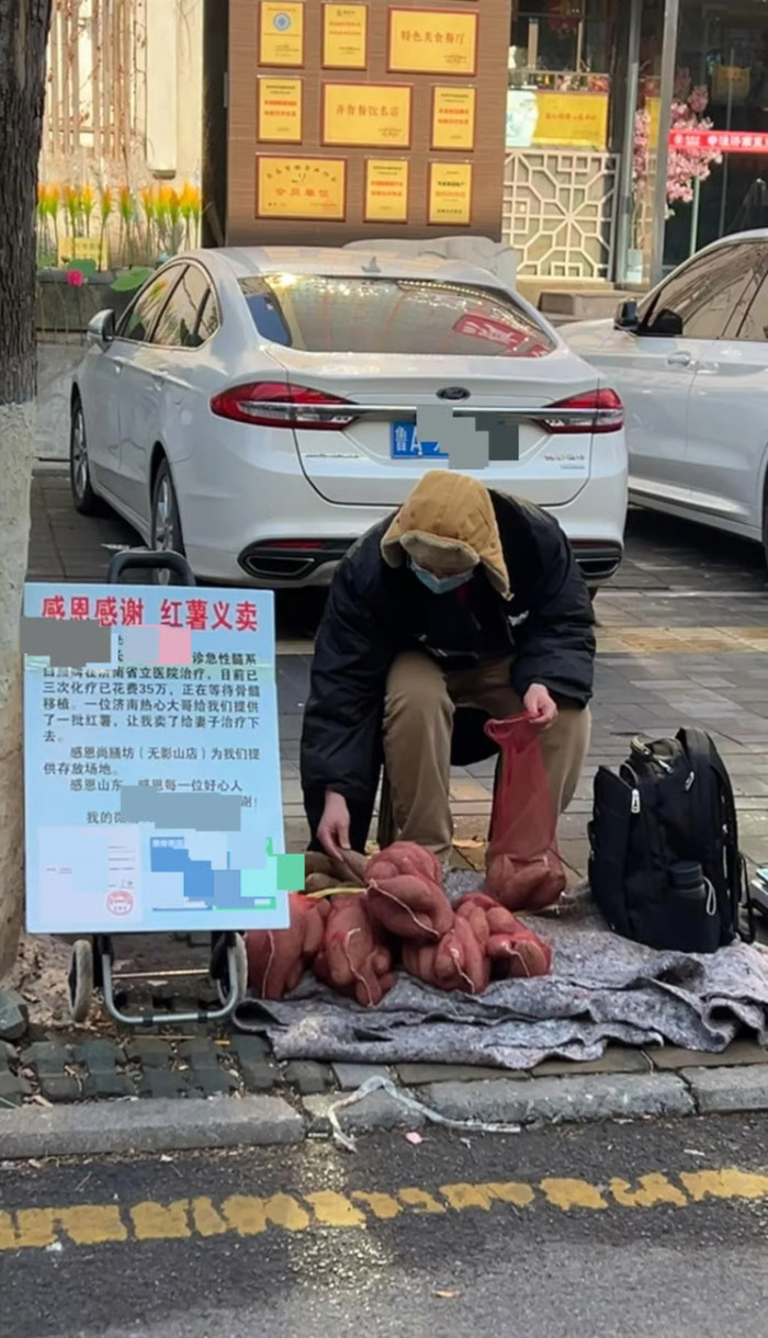 Hình ảnh cho thấy ông Jia đang bán khoai tây trên đường phố bên cạnh một tấm biển ghi tình trạng sức khỏe của vợ mình. Ảnh: QQ.com