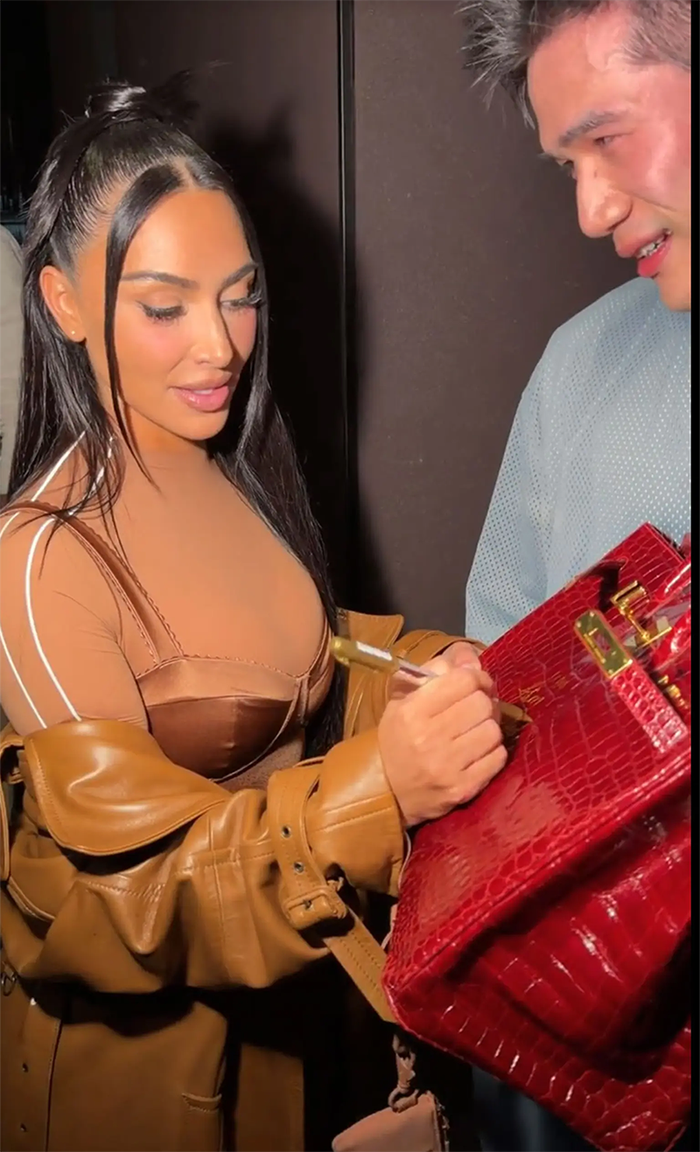 Người mẫu Kim Kardashian ký tên lên chiếc túi của fan.