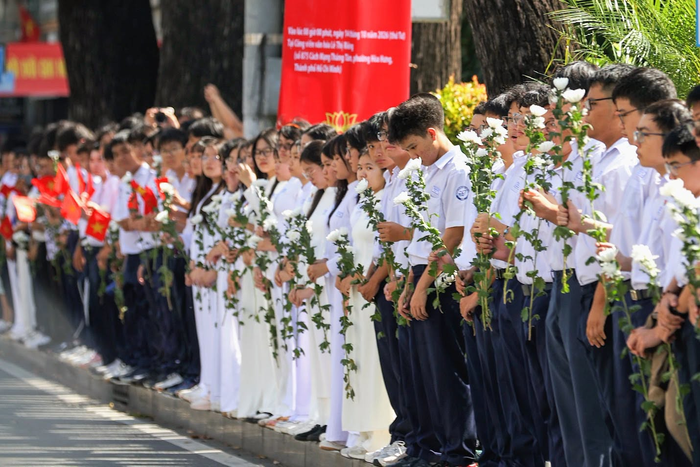 Người dân TP.HCM đứng dọc các tuyến đường nơi đoàn xe đi qua để đưa tiễn các anh hùng liệt sĩ. Ảnh: Thông Tin Chính Phủ.