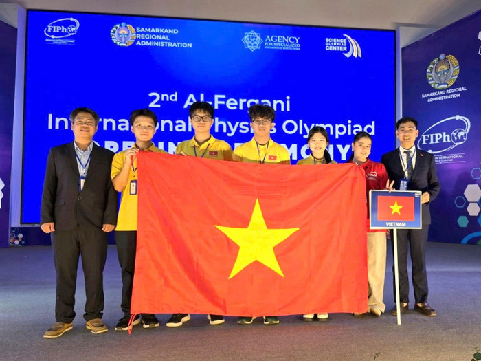 Đoàn học sinh Việt Nam tại FiPhO 2026 (Từ trái qua phải: PGS.TS Phạm Văn Hải, em Trương Bá Chí Thành, em Lê Bá Tuấn Việt, em Tăng Hạo Nhiên, em Lê Hồng Nhân, tình nguyện viên và PGS.TS Nguyễn Công Toản). Ảnh: Bộ GD&ĐT&nbsp;