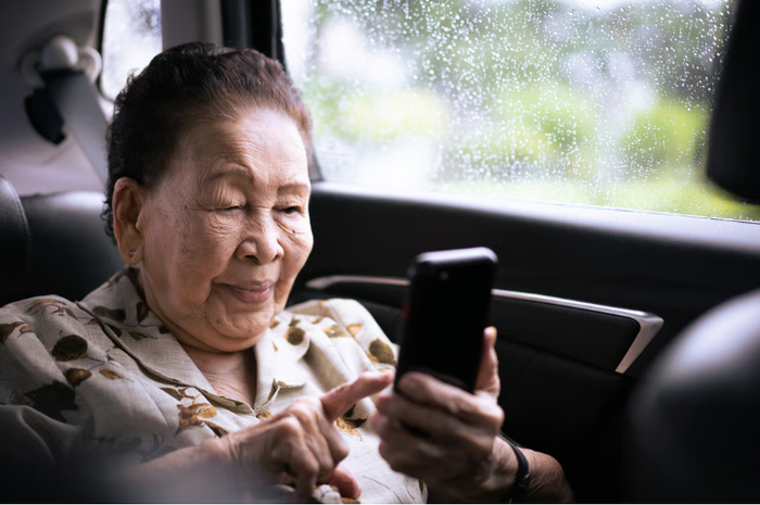 Một cụ bà thong thả gõ tin nhắn trên điện thoại di động. Ảnh: Shutterstock.