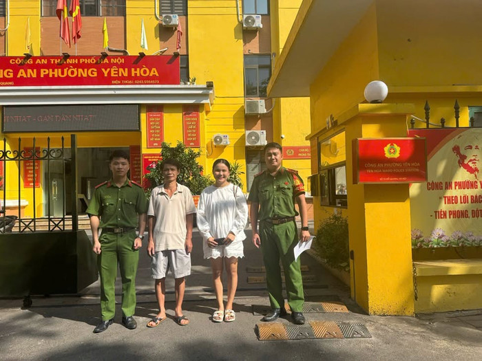 Cán bộ Công an phường Yên Hòa cùng anh Nguyễn Kim Hiệp trao trả chiếc ví cho chị Viên Thị Thơm. Ảnh: Công an TP Hà Nội