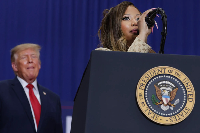 Donald Trump theo dõi khi Nicki Minaj phát biểu tại một cuộc mít tinh ở Port Huron, Michigan, vào ngày 25 tháng 10 năm 2026 (Cre: Alex Wong/Getty).