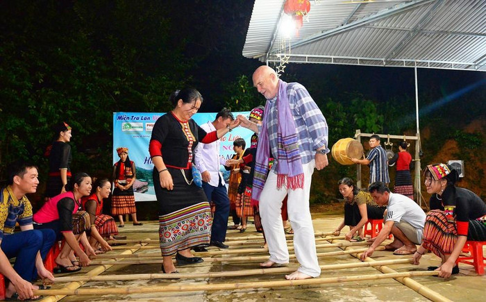 Du khách nước ngoài say sưa với điệu nhảy sạp tại điểm du lịch cộng đồng bản Khe Rạn, xã Bồng Khê, huyện Con Cuông. Ảnh: internet