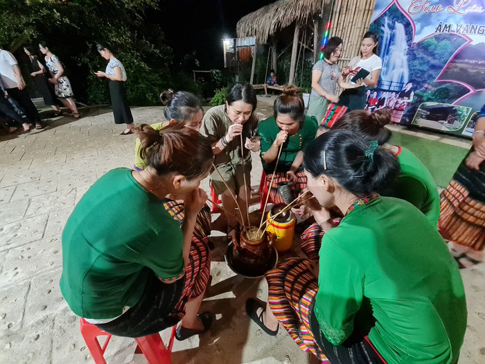 Khách du lịch trải nghiệm rượu cần tại bản Khe Rạn. Ảnh: Sức khỏe & Đời sống