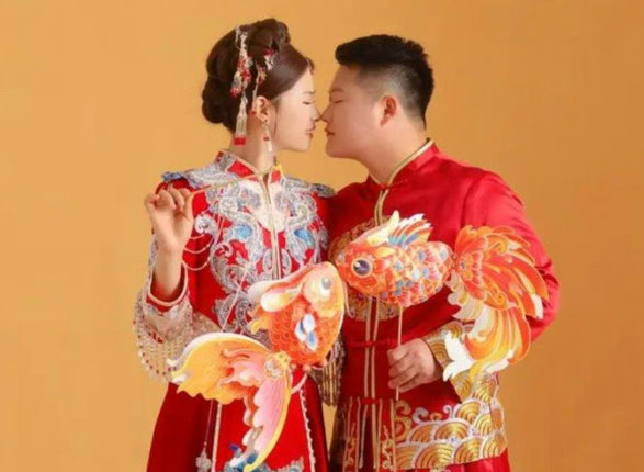 Cặp đôi trao nhau nụ hôn trong ngày cưới, diện trang phục truyền thống. Ảnh: www.worldjournal.com.