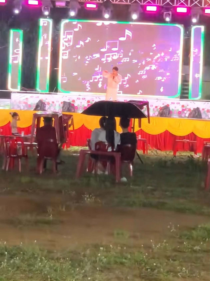 Khán giả thưa thớt ngồi xem, trong khi số khác bỏ đi chỗ khác để trú mưa.