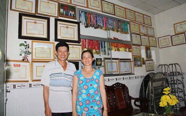 Bố mẹ của Ánh Viên chụp ảnh bên cạnh những thành tích của con gái. Ảnh: Huỳnh Xây