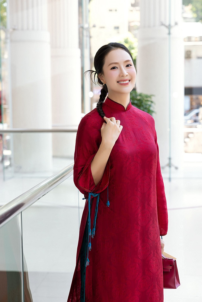 Cô cũng không ngại thử nghiệm với phong cách trẻ trung, năng động khi diện áo dài đỏ rực với họa tiết thêu nổi, phối cùng dây lưng màu xanh ngọc, xuất hiện trên phố cổ hay trung tâm thương mại. Ảnh: FBNV