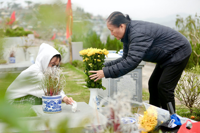 Bên phần mộ chồng, bà Nguyễn Thị Minh Thi (phường Ba Đình, Hà Nội) lặng lẽ bày biện lễ Tết.&nbsp;