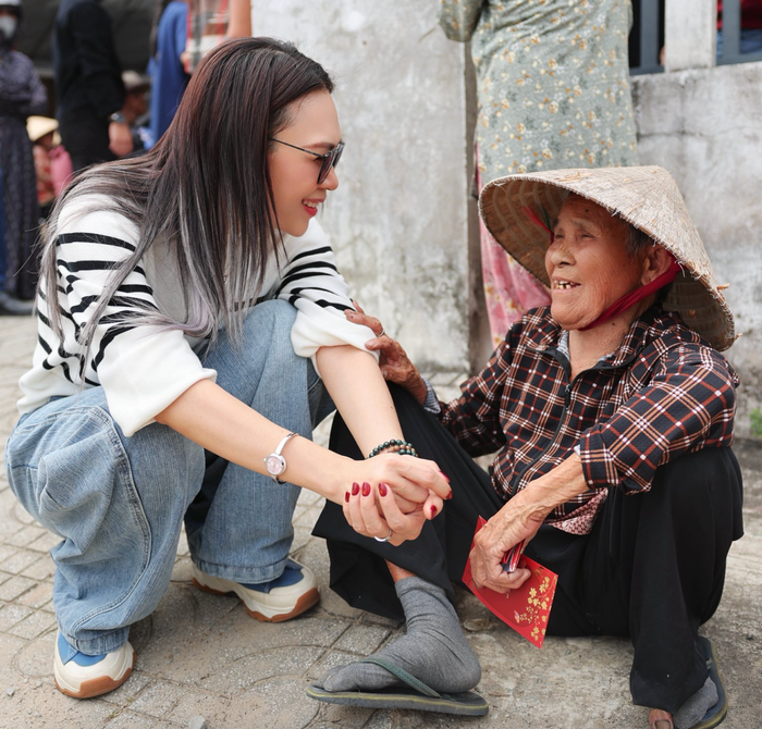 Mỹ Tâm tranh thủ trò chuyện với một bà cụ trong buổi phát quà thiện nguyện. Ảnh: FBNV