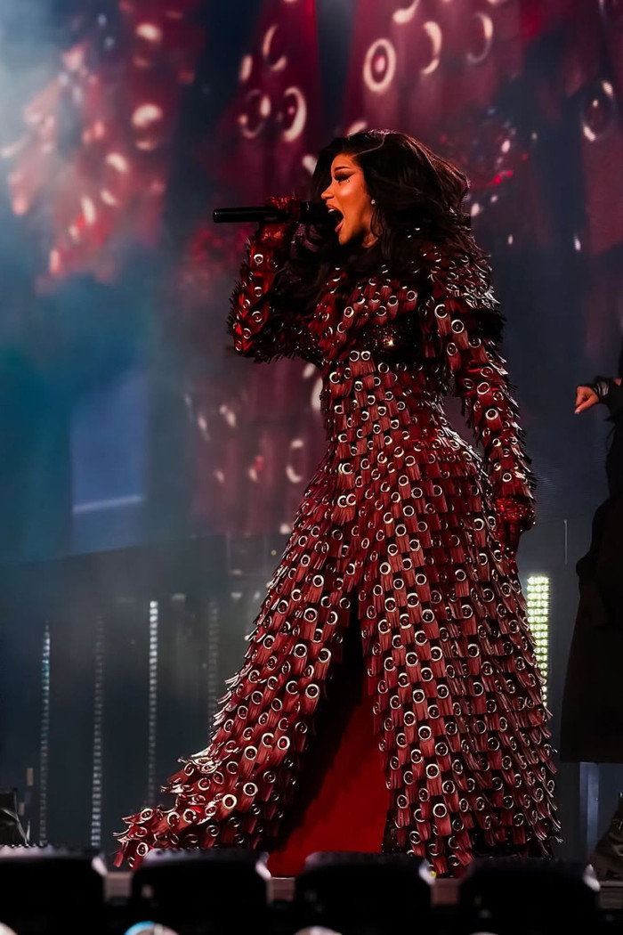 Cardi B bước ra với áo choàng dài, cấu trúc vai và cổ dựng đứng tạo hình tượng hoàng gia uy nghi.