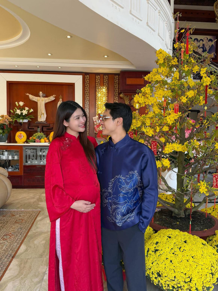 Á hậu Quỳnh Châu nổi bật trong tà áo dài đỏ nền nã, còn chồng của cô là CEO Phát Nguyễn diện áo dài navy họa tiết ngựa cách điệu đầy mạnh mẽ. Ảnh: FBNV