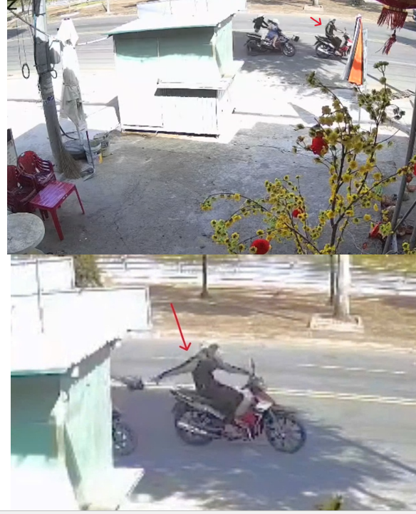 Hiện trường vụ cướp giật tài sản (ảnh từ camera hộ dân ghi lại). Trong ảnh: Đối tượng trùm áo khoác màu đen đang thực hiện hành vi cướp giật tài sản (mũi tên màu đỏ)