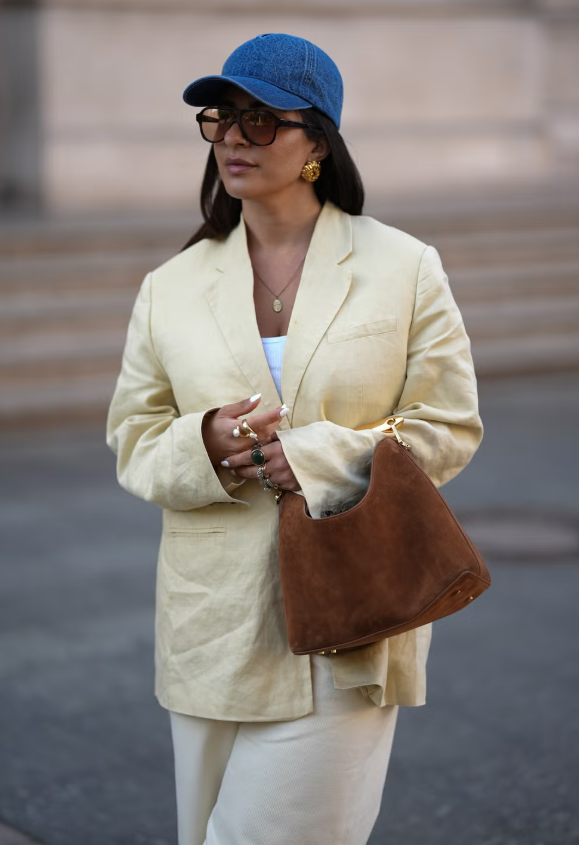 Denim thậm chí còn phủ sóng sang cả mũ. Từ mũ lưỡi trai đến mũ tai bèo, chỉ cần được làm từ chất liệu denim là đủ bắt nhịp xu hướng. Tại các quầy phụ kiện, không khó để bắt gặp loạt thiết kế gắn logo từ những thương hiệu được săn đón như Anine Bing hay Prada, biến món đồ tưởng chừng đơn giản này trở thành điểm nhấn thời thượng cho mọi bản phối. Ảnh: Elle