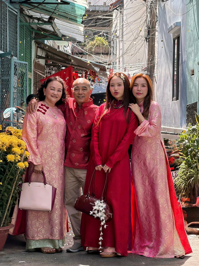 Phương Mỹ Chi diện áo dài đỏ thắm khi chụp ảnh cùng gia đình. Ảnh: FBNV