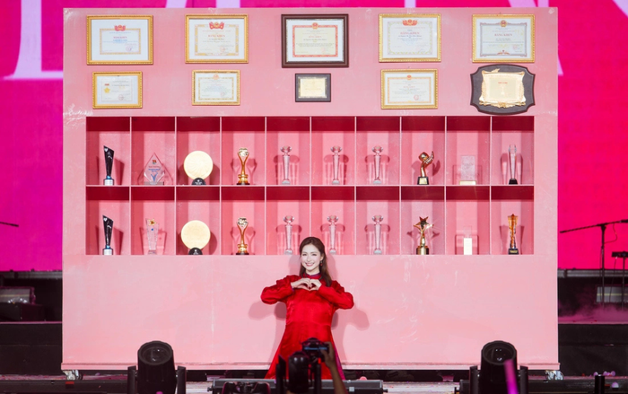 Hòa Minzy chụp ảnh cùng 28 bằng khen và chiếc cúp giải thưởng cho năm 2025. Ảnh: BTC concert Bắc Bling