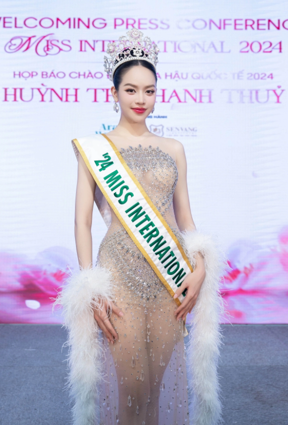 Hoa hậu Quốc tế 2024 gây ấn tượng khi diện thiết kế đầm sử dụng lớp vải lót nude tiệp da, phủ kín hàng ngàn viên đá và pha lê lấp lánh, tạo hiệu ứng như “đính kết trên da”. Các họa tiết được xử lý tập trung ở những điểm then chốt rồi thưa dần về phía chân váy, kết hợp dải lông vũ mềm mại nơi cánh tay, giúp tổng thể thêm phần sang trọng và cuốn hút dưới ánh đèn sân khấu. Ảnh: FBNV